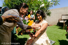 Indian relative applying tumeric paste to Maharani's arms Indian relative applying tumeric paste to Maharani's arms