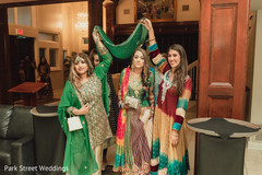 Indian bridesmaids holding a green veil over maharani's head. Indian bridesmaids holding a green veil over maharani's head.