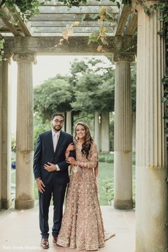 Indian bride on her pink Anarkali and groom on his black suit. Indian bride on her pink Anarkali and groom on his black suit.
