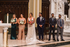 Indian couple standing in the with her bridesmaids and his groomsmen Indian couple standing in the with her bridesmaids and his groomsmen