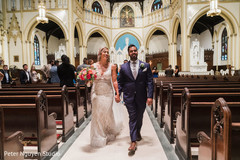 Indian newlyweds walking to the church exit Indian newlyweds walking to the church exit