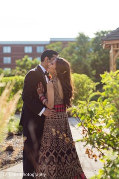 Indian groom talking to brides ear Indian groom talking to brides ear