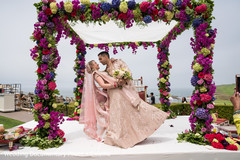Indian couple posing under colored flowers mandap. Indian couple posing under colored flowers mandap.