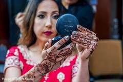Indian bride checking herself in a small mirror Indian bride checking herself in a small mirror