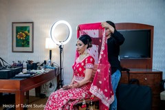 Hair artist putting a veil on the Indian bride Hair artist putting a veil on the Indian bride