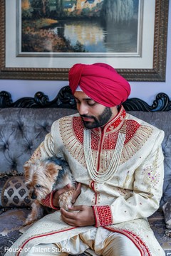 Indian groom playing with his dog on the waiting room Indian groom playing with his dog on the waiting room
