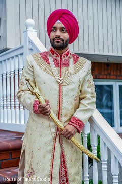 Indian groom posing on the stairs with a sword Indian groom posing on the stairs with a sword