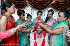 Indian relatives putting the decorations on the Indian groom's turban Indian relatives putting the decorations on the Indian groom's turban