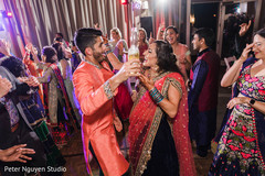 Indian couple dancing with guests at sangeet party. Indian couple dancing with guests at sangeet party.