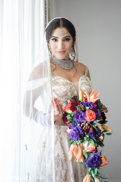 Maharani holding her coral and purple wedding bouquet. Maharani holding her coral and purple wedding bouquet.