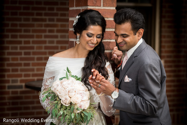 Indian groom admiring maharani's hand.