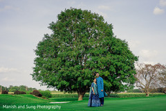 Indian couple posing in front of a tree Indian couple posing in front of a tree