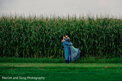 Indian groom holding his Maharani in front of a corn field Indian groom holding his Maharani in front of a corn field
