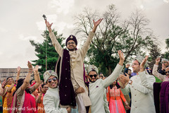 Indian groom being carried up in shoulders during Baraat Indian groom being carried up in shoulders during Baraat