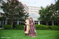 Lovely indian couple posing out in garden for first look. Lovely indian couple posing out in garden for first look.