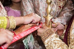 Indian groom cutting the red ribbon at milni celebration. Indian groom cutting the red ribbon at milni celebration.