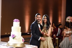 Indian couple next to Indian wedding cake. Indian couple next to Indian wedding cake.
