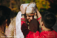 Indian relative putting a turban on the Indian groom Indian relative putting a turban on the Indian groom