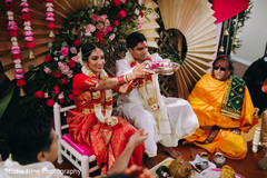 Indian couple presenting an offering during the ceremony Indian couple presenting an offering during the ceremony