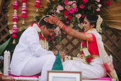 Maharani pouring seeds over her Indian groom's head Maharani pouring seeds over her Indian groom's head