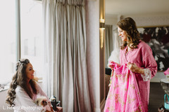 Maharani with bridesmaids looking at pink lehenga skirt. Maharani with bridesmaids looking at pink lehenga skirt.