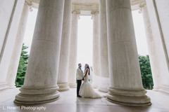 Indian couple posing in between big white columns. Indian couple posing in between big white columns.