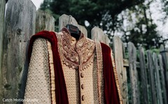 Indian groom's ivory, golden and burgundy sherwani outfit. Indian groom's ivory, golden and burgundy sherwani outfit.
