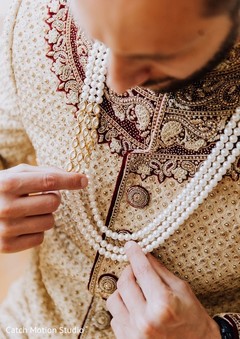 Indian groom putting his wedding ceremony necklace. Indian groom putting his wedding ceremony necklace.
