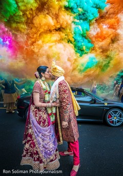 Indian couple kissing in front of an explosion of colors Indian couple kissing in front of an explosion of colors
