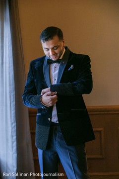 Indian groom putting on his reception suit. Indian groom putting on his reception suit.