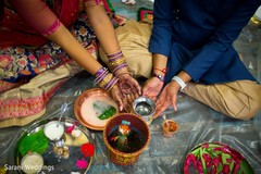 Indian bride and groom touching sacred pot. Indian bride and groom touching sacred pot.