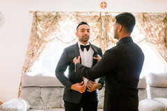 Indian relative helping the Indian groom with his suit Indian relative helping the Indian groom with his suit