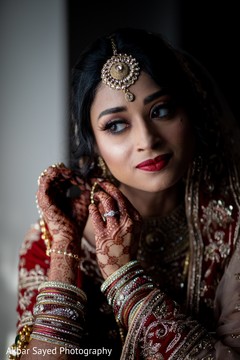 Indian bride putting on her ceremony earrings. Indian bride putting on her ceremony earrings.
