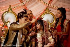 Indian groom putting red mark on maharani's forehead. Indian groom putting red mark on maharani's forehead.
