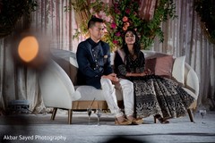 Indian couple seating on white reception stage sofa. Indian couple seating on white reception stage sofa.