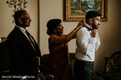 Indian groom getting his bow tie on . Indian groom getting his bow tie on .