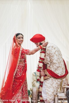 Indian bride putting a necklace on her Indian groom Indian bride putting a necklace on her Indian groom