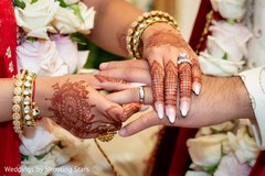 Indian bride putting a ring on her Indian groom's hand Indian bride putting a ring on her Indian groom's hand