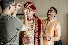 Indian groom getting his red turban on. Indian groom getting his red turban on.