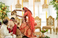 Indian bride pouring rice into grooms head. Indian bride pouring rice into grooms head.