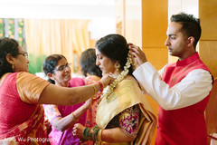 Indian bride getting her flower necklace on . Indian bride getting her flower necklace on .