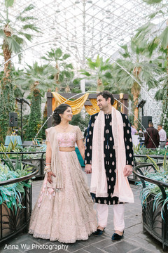 Indian couple in their light pink and black sangeet outfits. Indian couple in their light pink and black sangeet outfits.