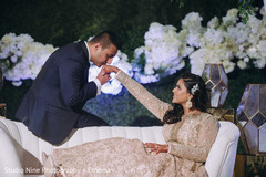 Indian bride and groom posing at reception white sofa. Indian bride and groom posing at reception white sofa.