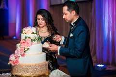 Indian couple cutting whiten and golden wedding cake. Indian couple cutting whiten and golden wedding cake.