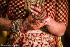 Indian bride putting on her wedding braceletes . Indian bride putting on her wedding braceletes .