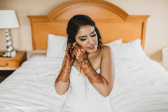 Indina bride putting her earing capture. Indina bride putting her earing capture.