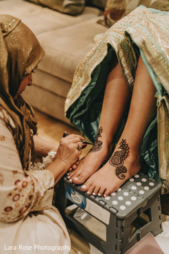 Indian bride getting her mehndi art on feet. Indian bride getting her mehndi art on feet.