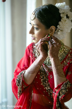 Indian bride putting her earings on. Indian bride putting her earings on.