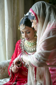 Indian bride putting on her red bangles. Indian bride putting on her red bangles.