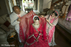 Indian bride's relatives putting her ghoonghat on. Indian bride's relatives putting her ghoonghat on.